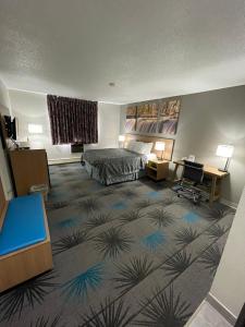 a hotel room with a bed and a desk at Days Inn by Wyndham Alpena in Alpena