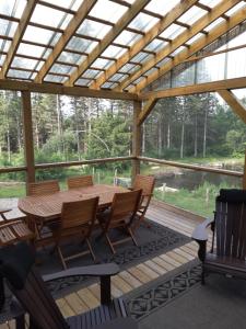 un patio con una mesa de madera y sillas en una terraza en GÎTE SUR L'ARC EN CIEL, en Saint Adrien