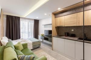 a living room with a couch and a bed at Inter Holiday Apartments in Pomorie