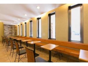 a row of tables and chairs in a room with windows at R&B Hotel Kanazawa Station Nishiguchi - Vacation STAY 14975v in Kanazawa