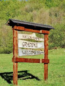 een houten bord in het gras in een veld bij Gradine - Katun kamp in Plav