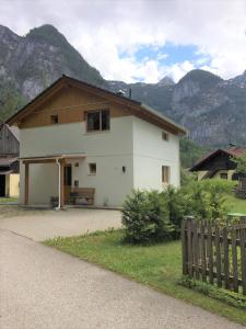 a white house with mountains in the background at Apartment Obertraun in Obertraun