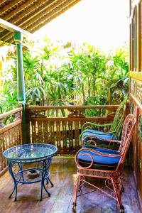 a patio with two chairs and a table on a porch at Bali Bohemia Huts in Ubud