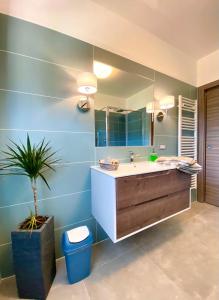 a bathroom with a sink and a large mirror at Casa Ortensia in Pellizzano