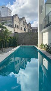 een blauw zwembad voor een gebouw bij Flat de luxo centro SP com piscina,academia,lavanderia,garagem e segurança 24h in Sao Paulo