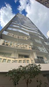 een hoog gebouw met een boom ervoor bij Flat de luxo centro SP com piscina,academia,lavanderia,garagem e segurança 24h in Sao Paulo