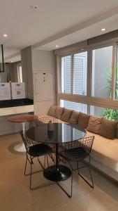 een woonkamer met een bank en een tafel en stoelen bij Flat de luxo centro SP com piscina,academia,lavanderia,garagem e segurança 24h in Sao Paulo