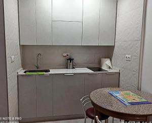 a small kitchen with a table and a sink at Apartamentos Sol y Playa Almuñecar 2 in Almuñécar