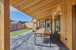 a wooden house with a table and chairs on a patio at Vakantiehuis Sahara119 in Lommel