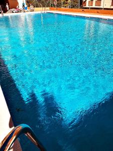 a large swimming pool with blue water at Apartamentos Sol y Playa Almuñecar 2 in Almuñécar