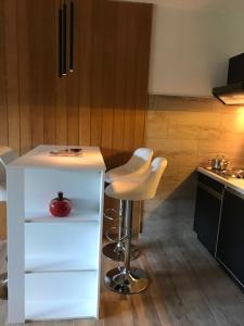 eine Küche mit einer weißen Theke und einem Stuhl in der Unterkunft Schöne Ferienwohnung im Südschwarzwald in Herrischried