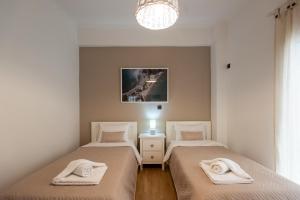 sypialnia z 2 łóżkami i ręcznikami w obiekcie Blue Ark Loving Athens w Atenach