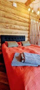um quarto com uma cama vermelha num chalé de madeira em Cozy Log Cabin by Invisible Forest Lodge em Rovaniemi
