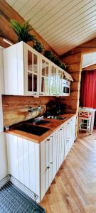 a kitchen with white cabinets and a counter top at Cozy Log Cabin by Invisible Forest Lodge in Rovaniemi