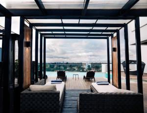 a patio with couches and chairs on a roof at Trademark Hotel, a Member of Design Hotels in Nairobi