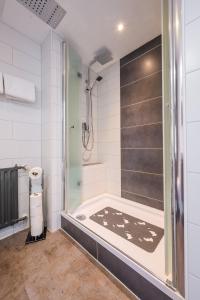 a bathroom with a shower and a tub at Hotel Kaspar Garni in Siegburg