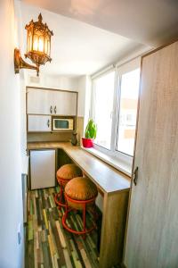 eine Küche mit zwei Hockern und einer Theke mit einem Fenster in der Unterkunft Guest House Гостевой Дом in Chişinău