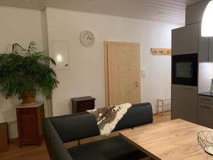 a living room with a couch and a table and a clock at Casa Restelli EG - nahe Andermatt Gotthard in Gurtnellen