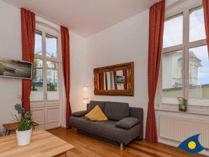 Una sala de estar con un sofá y algunas ventanas. en Villa Frisia Whg 22, en Bansin