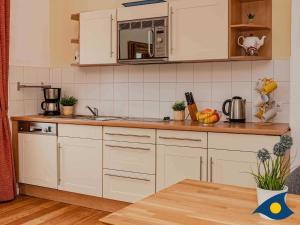 Una cocina con gabinetes blancos y encimera. en Villa Frisia Whg 22, en Bansin