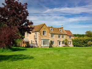 a large brick house on a green lawn at Corn Close in Moreton in Marsh