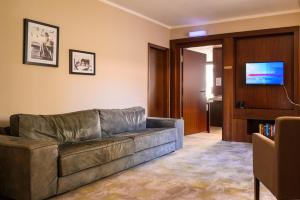 a living room with a couch and a flat screen tv at Hotel Kaspar Garni in Siegburg