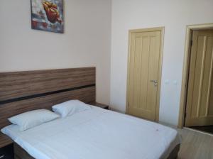 a bedroom with a bed and a dresser at Best Season Apart Hotel in Kyiv