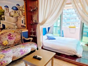 a bedroom with a bed and a chair and a table at Migo House in Kaohsiung