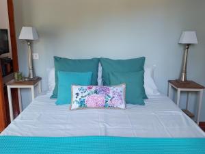 a bed with blue pillows and a pillow on it at Casa La Quercia- Tra Cefalù ed il Parco delle Madonie in Gratteri