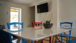 a dining room table with a vase on it with colorful chairs at Apartment Aria in Verunić
