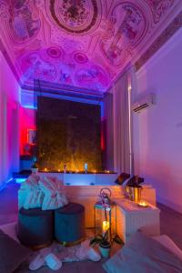 カターニアにあるB&B Palazzo Bruca Cataniaのリビングルーム(ソファ付)、ピンクの照明付きの天井
