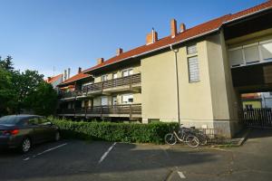 Una bicicleta estacionada en un aparcamiento al lado de un edificio en Centrum Apartman Kőszeg, en Kőszeg