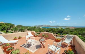 a patio with chairs and a table and a view of the ocean at SARDINIA RE - Villa Ginepri in Stintino