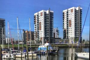 a group of boats docked in a marina with tall buildings at Aaram Se at My Retreat in Gillingham