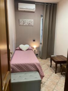 Dormitorio pequeño con cama y mesa en VILLA MARIPOSA en Nettuno