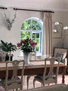 una sala da pranzo con tavolo, sedie e finestra di Lovely Studio Apartment with Roof Top Conservatory a Goostrey