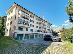 un edificio con un coche aparcado delante de él en Seeblick an Luxusmeile 4P, 70m2 - Parkplatz, - S11-1 en St. Moritz
