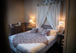 a bedroom with a bed with two pillows and curtains at La Maison Douce in Saint-Martin-de-Ré