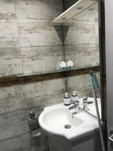 La salle de bains est pourvue d'un lavabo blanc et d'un miroir. dans l'établissement Jolie studio, à Rueil-Malmaison