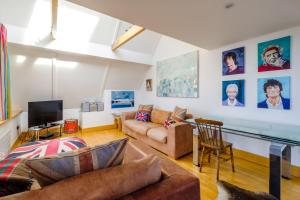 a living room with a couch and a tv at Gunfleet, Aldeburgh - A Large Seafront House with Stunning Sea Views from all the floors, Sleeps 14 - Aldeburgh Coastal Cottages in Aldeburgh