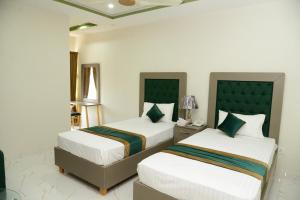 A bed or beds in a room at Hotel Deluxe Johar Town Lahore