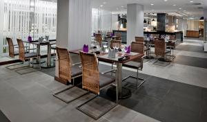 a dining room and kitchen with tables and chairs at Eastin Grand Hotel Saigon in Ho Chi Minh City