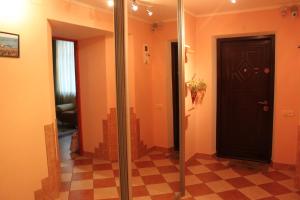 a hallway with a black door and a checkered floor at Apart-Hotel on Preobrajenskaya 24 in Odesa