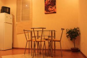 a table and chairs in a kitchen with a refrigerator at Apart-Hotel on Preobrajenskaya 24 in Odesa