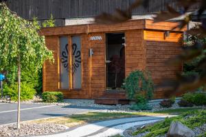 a small wooden building with a sign on the door at Grand Tatry - miejsce na wyjątkowy pobyt dla Ciebie i Twojej rodziny! - sauna i jacuzzi wliczone w cenę pobytu - 10 minut pieszo od Term Bania in Białka Tatrzańska +178 photos
