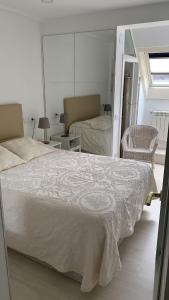 een slaapkamer met een groot wit bed en een spiegel bij SALESAS OVIEDO CENTRO COMERCIAL CORTE NGLES- Apartamento in Oviedo