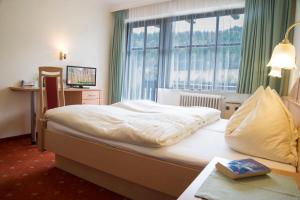 ein Hotelzimmer mit einem Bett und einem Fenster in der Unterkunft Taxenbacherhof in Taxenbach