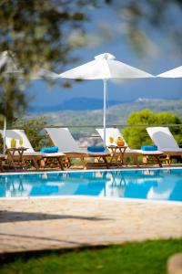 a group of chairs and umbrellas next to a swimming pool at Olympion Asty Hotel in Olympia