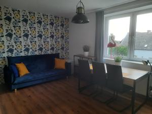 a living room with a blue couch and a table at Kuznica Zorza Bałtyku Złoty in Kuźnica