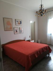 een slaapkamer met een rood bed en een kroonluchter bij Donna Concetta in Mazara del Vallo